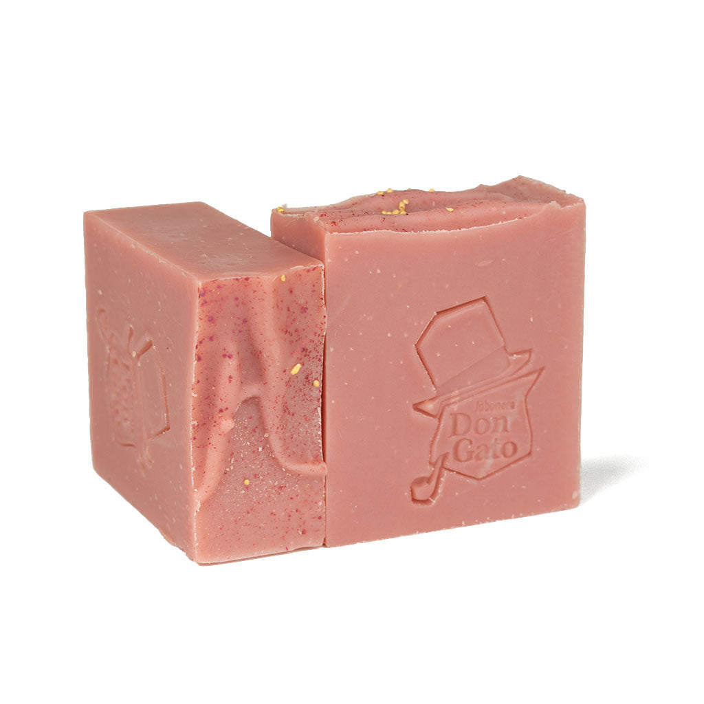  A dusty rose Midnight Berry soap bar with an embossed Don Gato logo in bright natural light.
