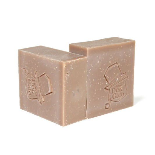 Two lilac-gray Don Gato Cashmere soap bars with embossed logos in bright natural light